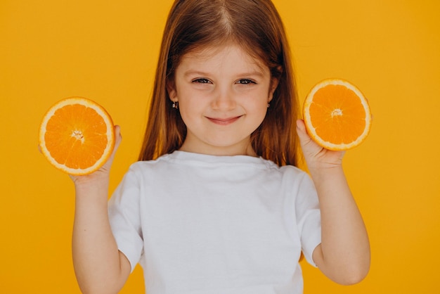 Mała dziewczynka z pomarańczami odizolowana w studio