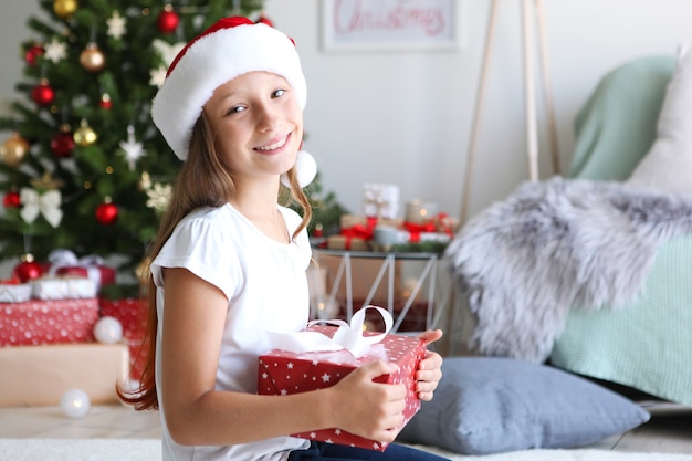 Mała dziewczynka z prezentami świątecznymi w świątecznym wnętrzu