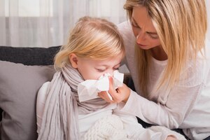 Mała dziewczynka z przeziębieniem i dmuchaniem w nos