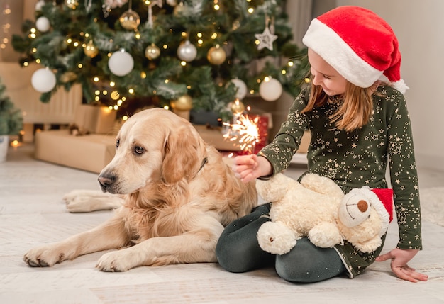 Mała dziewczynka z psem golden retriever w okresie Bożego Narodzenia