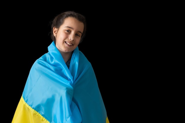 Mała dziewczynka z ukraińską flagą na ciemnym tle