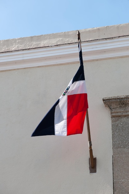 Mała flaga Dominikany wisząca na ścianie na zewnątrz