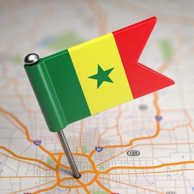 Mała flaga Senegalu na tle mapy z selektywną ostrością.