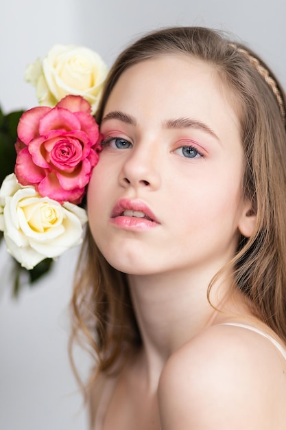Mała ładna dziewczynka w kolorze różowym trzyma bukiet róż Zbliżenie kwiaty i twarz Piękna mała dziewczynka z kwiatami