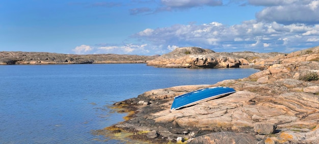 Mała niebieska łódka wróciła na szwedzkie granitowe wybrzeże nad Morzem Bałtyckim na wyspie Smogen