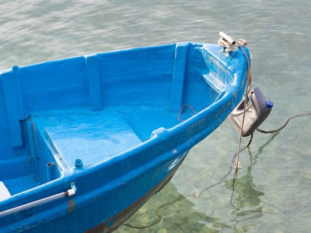 Mała niebieska łódź rybacka zacumowana w porcie.