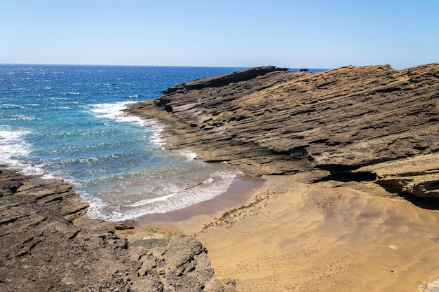 Mała niesamowita plaża ukryta między dramatycznymi klifami na Teneryfie Wyspy Kanaryjskie Hiszpania słoneczny letni dzień