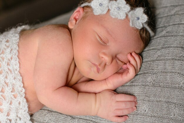 Zdjęcie mała nowonarodzona dziewczynka w wieku ośmiu dni. zakończenie piękna sypialna dziewczynka