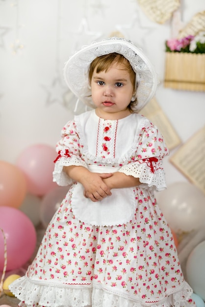 Mała piękna dziewczynka w sukience dla lalek i kapeluszu