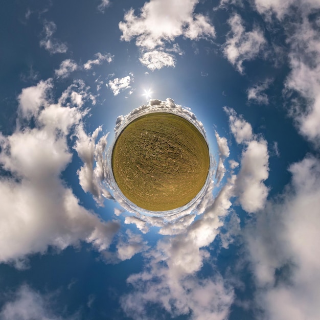 Mała planeta na niebieskim niebie ze słońcem i pięknymi chmurami Transformacja sferycznej panoramy 360 stopni Sferyczny abstrakcyjny widok z lotu ptaka Krzywizna przestrzeni