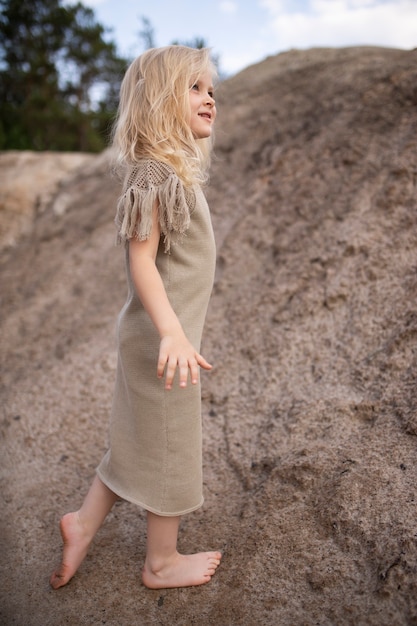 Mała śliczna dziewczyna w stylowe ubrania w scenerii przyrody