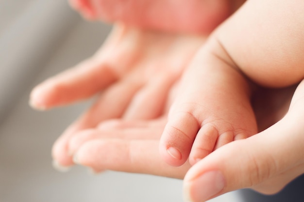 Mała stopa noworodka w kobiece dłonie zbliżenie
