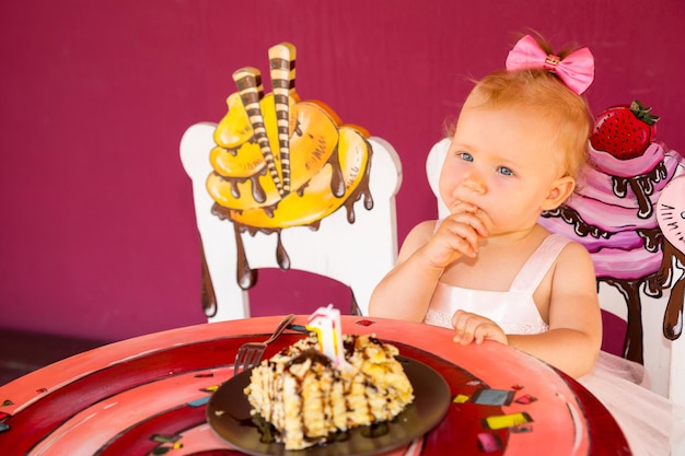 Mała szczęśliwa dziewczynka świętuje pierwsze urodziny Dziecko i jej pierwszy tort na imprezie Dzieciństwo