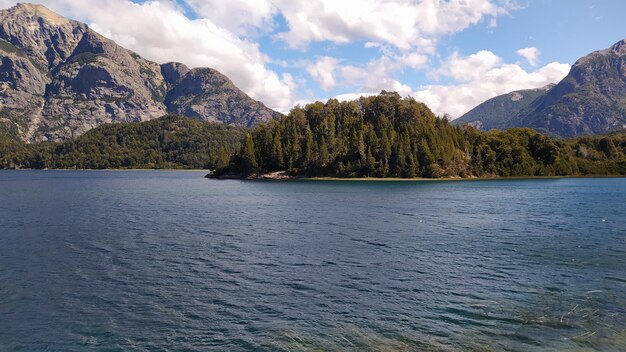 Zdjęcie mała wyspa pośrodku jeziora z górami w tle