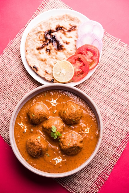 malai kofta curry - klasyczne danie północnoindyjskie. wegetariańska alternatywa dla pulpetów podawana z tandoori roti lub indyjskim chlebem i zieloną sałatą, selektywne skupienie