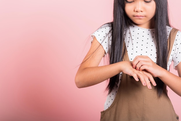 Małe azjatyckie dziecko w wieku 10 lat drapie się w plecy od ugryzienia komara