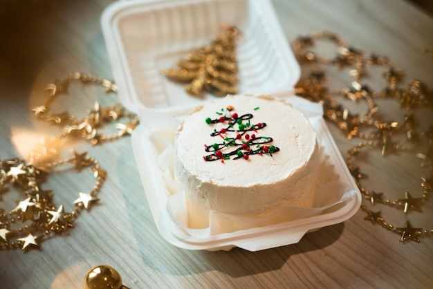 Małe białe ciasto bento z dekoracją choinki w stole Zdjęcie w świątecznym nastroju dla zawartości cukiernika