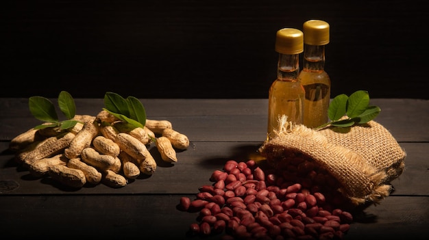 Zdjęcie małe buteleczki z olejem arachidowym z orzechami w łupinach i organicznymi ziarnami