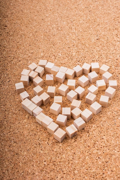 Małe drewniane kostki tworzą kształt serca lub symbol walentynek