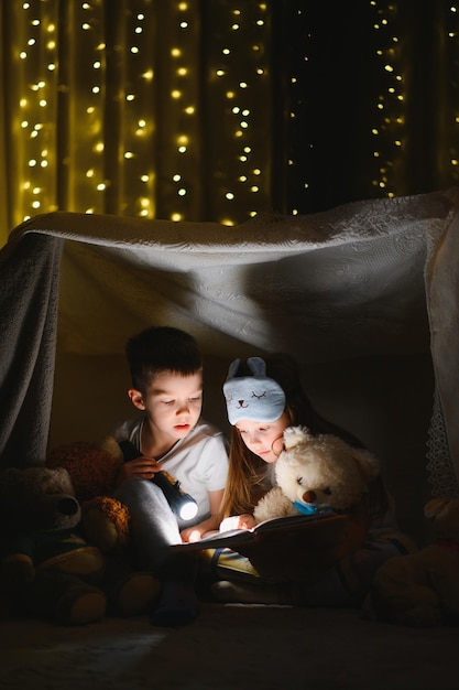 Małe dzieci czytają bajki na dobranoc w domu