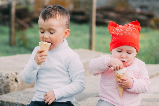 Małe dzieci jedzą lody na świeżym powietrzu w wiosce