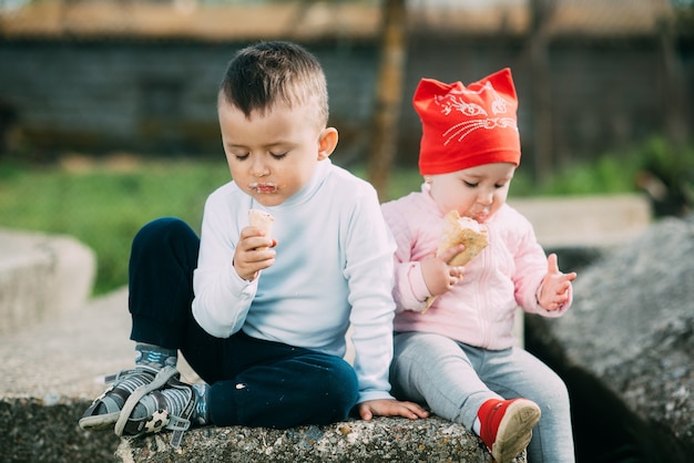 Małe dzieci jedzą lody na świeżym powietrzu w wiosce