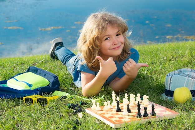 Małe dziecko gra w szachy Dziecko gra w grę planszową Myślące dziecko burza mózgów i pomysł w grze w szachy Szachowa koncepcja szkoły i edukacji