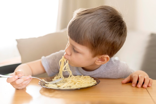 Zdjęcie małe dziecko je spaghetti