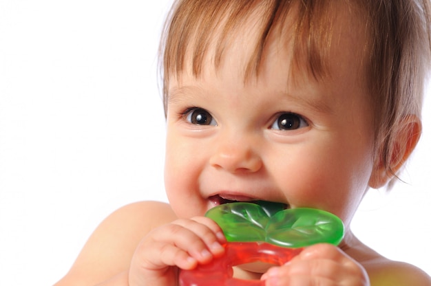 Małe dziecko jednego roku trzyma pod ręką kolorową zabawkę ząbkowanie.