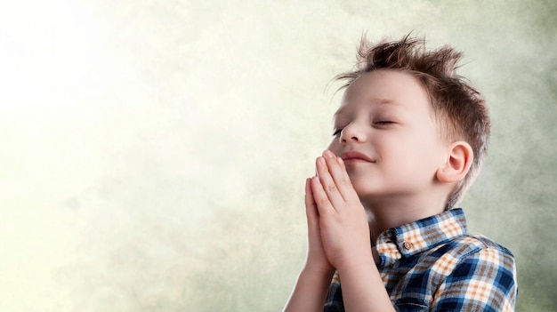 małe dziecko modlące się do Boga ze złożonymi rękami i uśmiechem