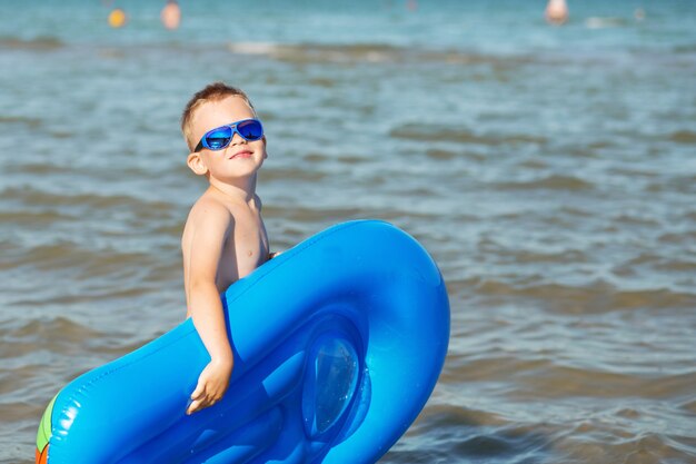 Małe Dziecko Trzymające Dmuchany Materac Na Plaży W Upalny Letni Dzień