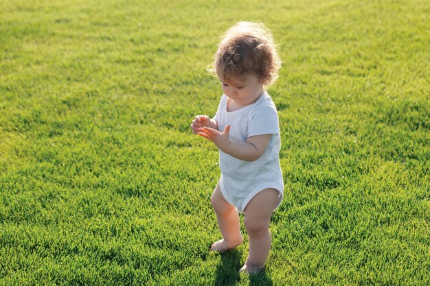 Małe dziecko uczy się pełzać po schodach na trawie Koncepcja miesiące dla dzieci Szczęśliwe dziecko bawiące się na gre