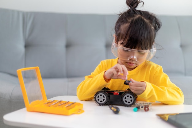 Małe dziewczynki bawią się w warsztacie kodującym samochód robota