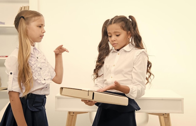 Małe dziewczynki omawiają problem w dniu szkolnym Małe dziewczynki pracują nad rozwiązaniem problemu w klasie