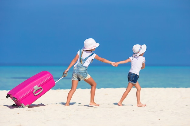 Małe Dziewczynki Turystów Z Dużą Walizką Na Tropikalnej Plaży Biały