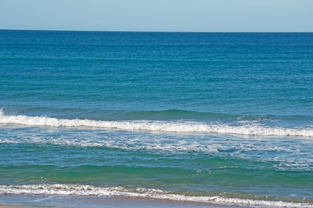 Małe fale w pogodny dzień na plaży Platamona na Sardynii