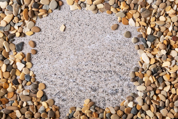 Małe kamienie na tle mokrego piasku Tekstura do projektowania