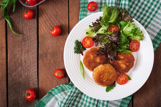 Małe kotlet z kurczaka z warzywami na talerzu