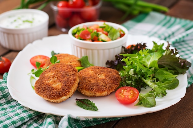 Zdjęcie małe kotlet z kurczaka z warzywami na talerzu