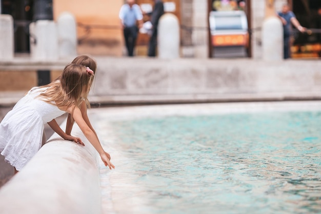 Małe piękne dziewczynki w pobliżu fontanny Fontana di trevi