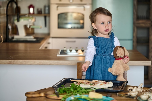 Małe słodkie dziecko gotuje pizzę w kuchni Koncepcja szczęśliwej rodziny