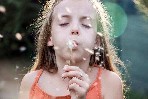 Małego dziecka podmuchowy dandelion w pogodnym letnim dniu