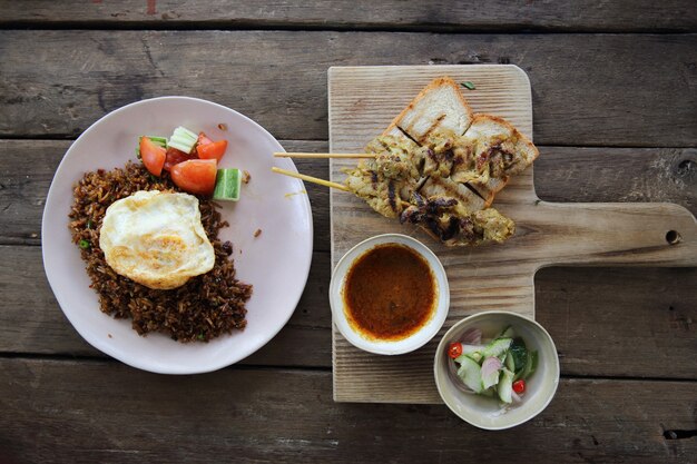 Malezyjskie jedzenie satay z kurczaka z sosem orzechowym na tle drewna
