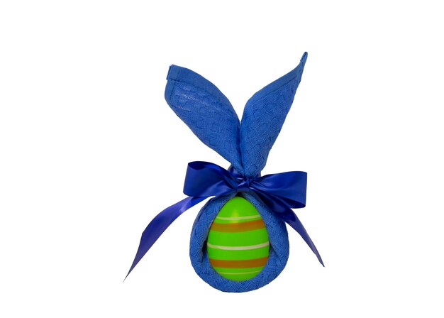 Zdjęcie malowane jajko zawinięte w niebieską serwetkę w kształcie uszu jest izolowane na białym tle
