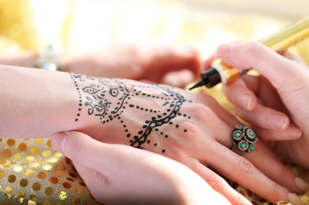 Malowanie tatuażu henną na kobiecej ręce