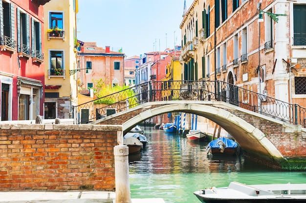 Malowniczy kanał z mostem i kolorowymi budynkami w Wenecji, Włochy