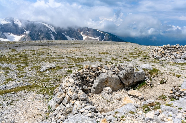 Malowniczy panoramiczny widok na idylliczny krajobraz wzgórz z kwitnącymi łąkami i ośnieżonymi szczytami alpejskimi