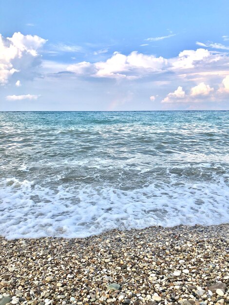 Zdjęcie malowniczy widok na morze przez kamienie na plaży na tle pochmurnego nieba