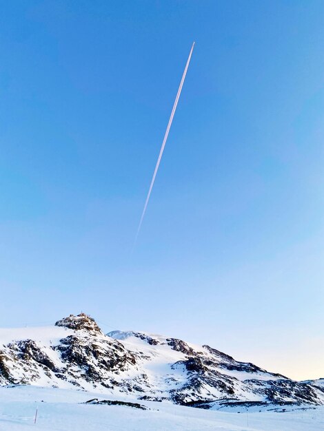 Malowniczy widok na pokryte śniegiem góry na tle czystego niebieskiego nieba