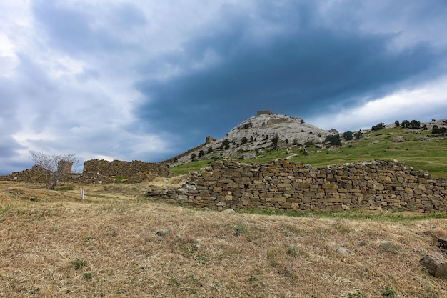 Malowniczy widok z burzowym niebem na Górę Fortecy i starożytną fortecę genueńską